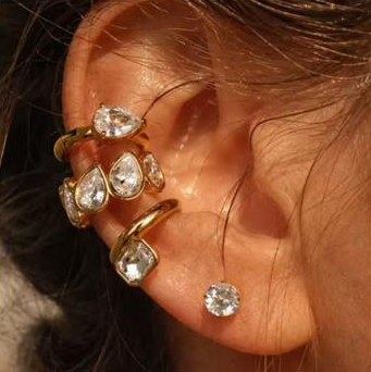 Ohr mit goldenen Ear Cuffs und klaren Tropfensteinen