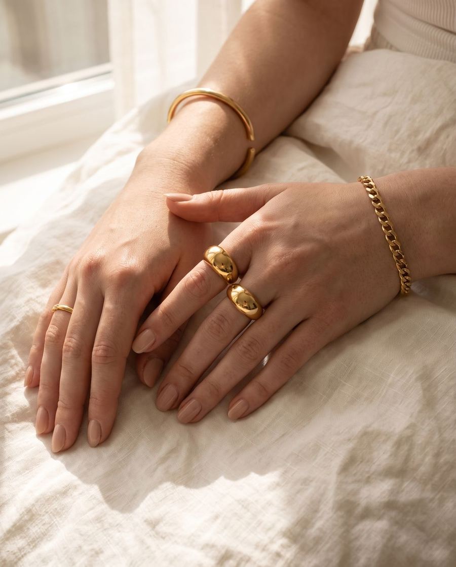 Hand mit zwei breiten goldenen Ringen